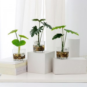 Plante artificielle en pot dans l\'eau d\'imitation avec des articles de verre